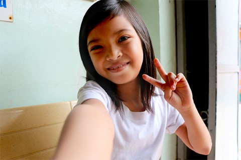 Arianne flashes a sweet sign to match her sweet smile.