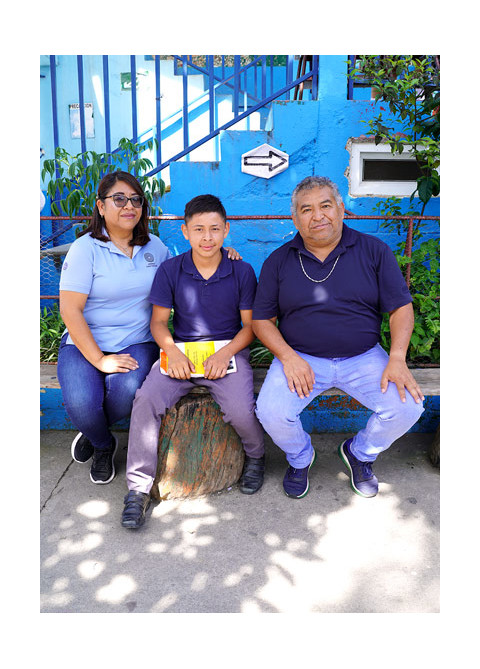 a boy, woman and teacher seating outside of a community center