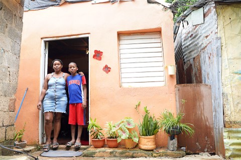 a woman and a boy outside their home